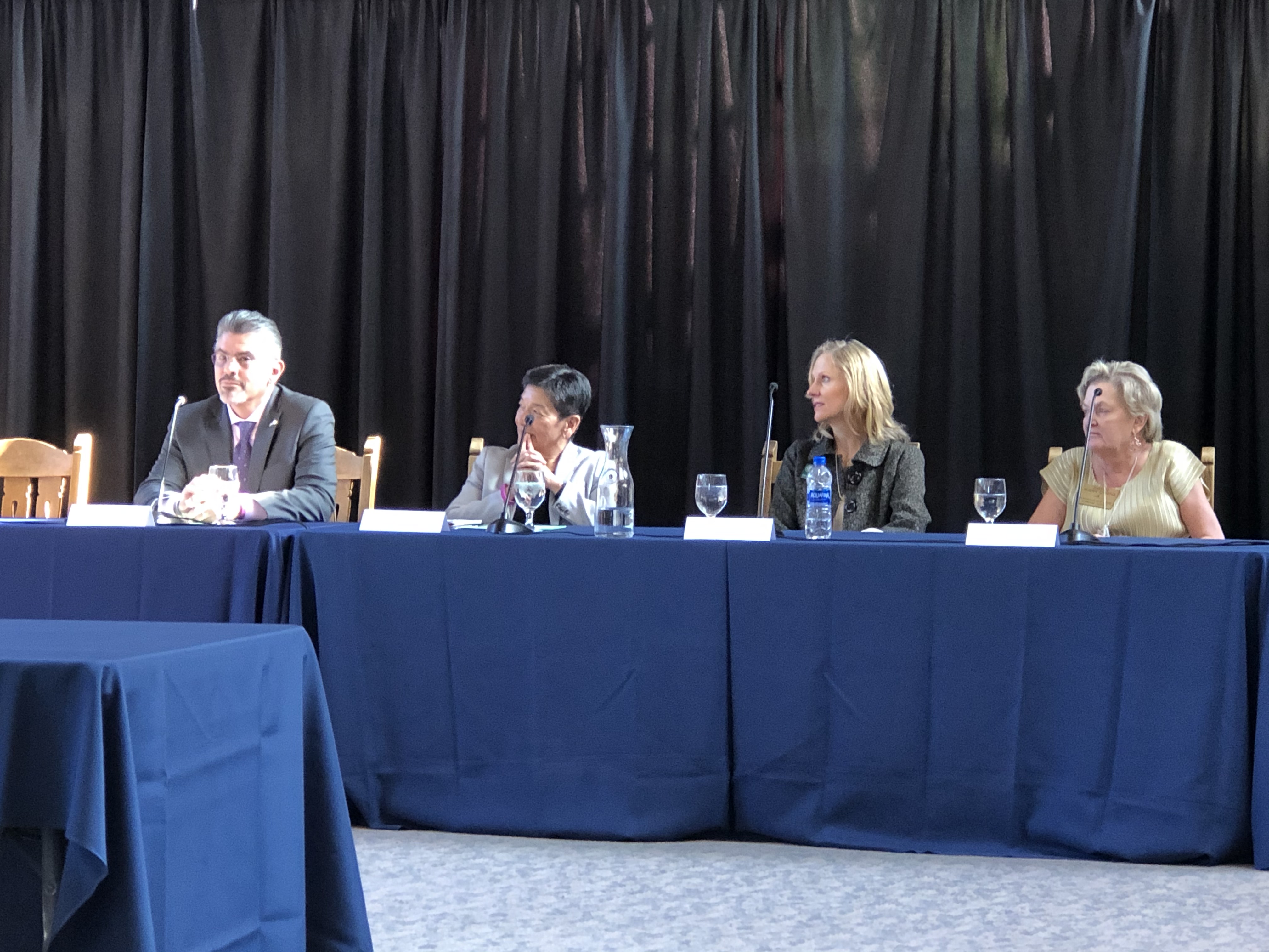 Justices Steven C. González, Mary I. Yu, Debra L. Stephens and Susan Owens sit behind a table, listening to the moderator's question.