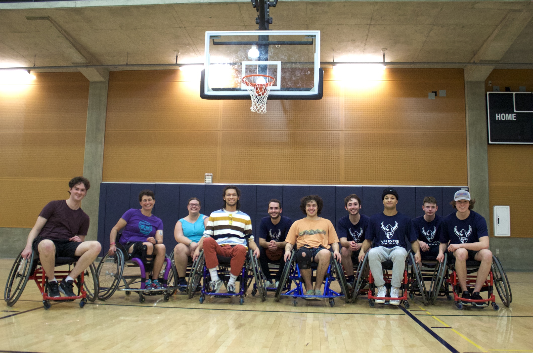 The people who participated in the wheelchair basketball event pose for a group photo.